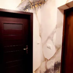 Korytarz z dekoracyjną ścianą imitującą marmur z złotymi żyłkami, widoczne dwie ciemne drewniane drzwi.