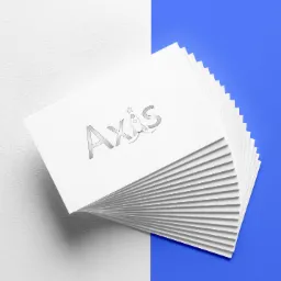 Stos białych wizytówek z szarym logo Axis (rakieta ze gwiazdą) na tle podzielonym na białą i niebieską część.