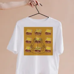 Biała koszulka z unikalnym nadrukiem w Warszawie, przedstawiającym kontur kota w koronie otoczonego tostami z bekonem, prezentowana na wieszaku.