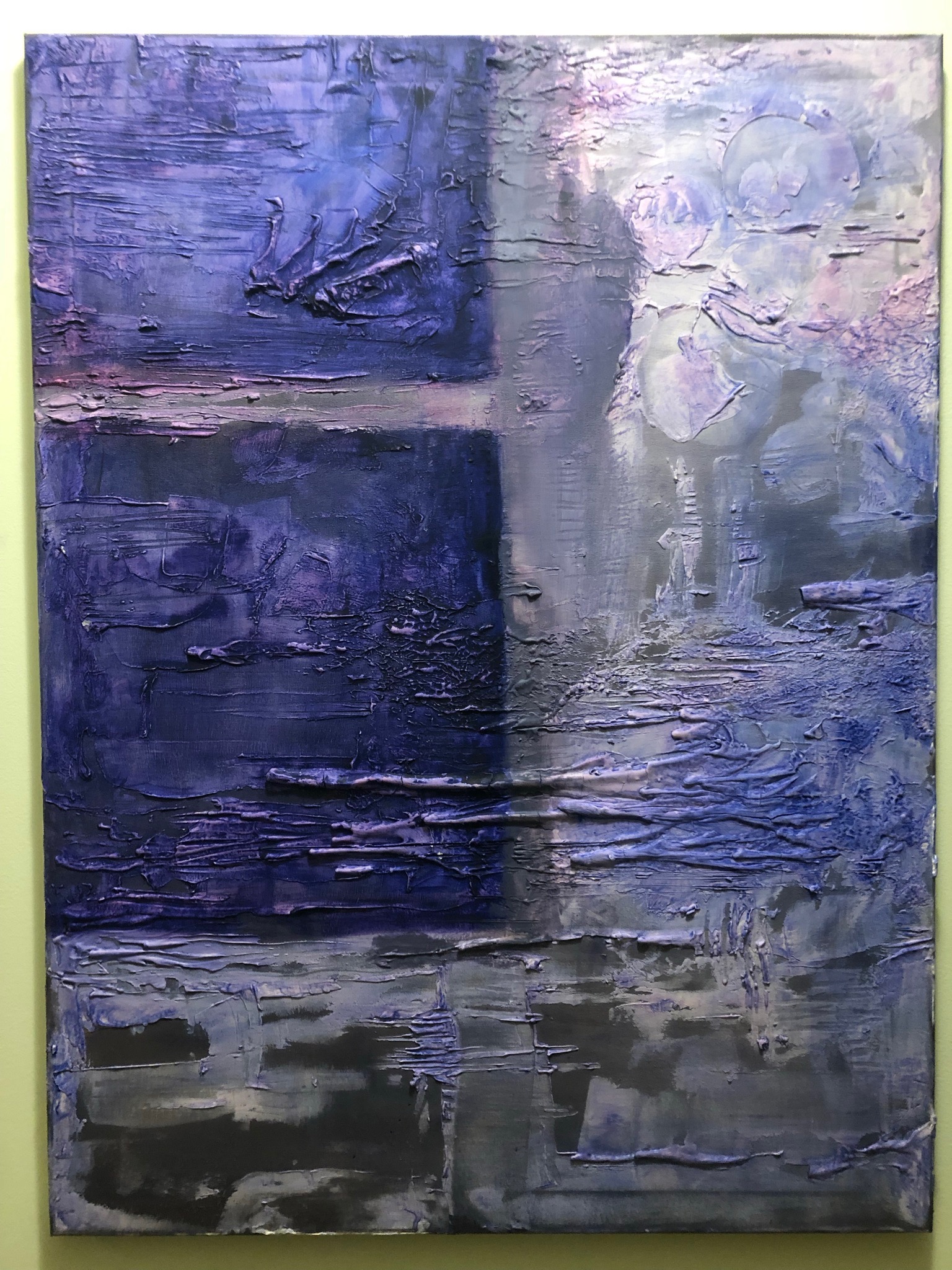 Abstrakcyjna kompozycja malarska w odcieniach fioletu i szarości z wyraźną fakturą, podzielona na kwadratowe segmenty z nałożonymi warstwami farby.