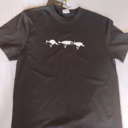 Ciemna koszulka z nadrukiem trzech białych przynęt wędkarskich, leżąca na jasnym tle.