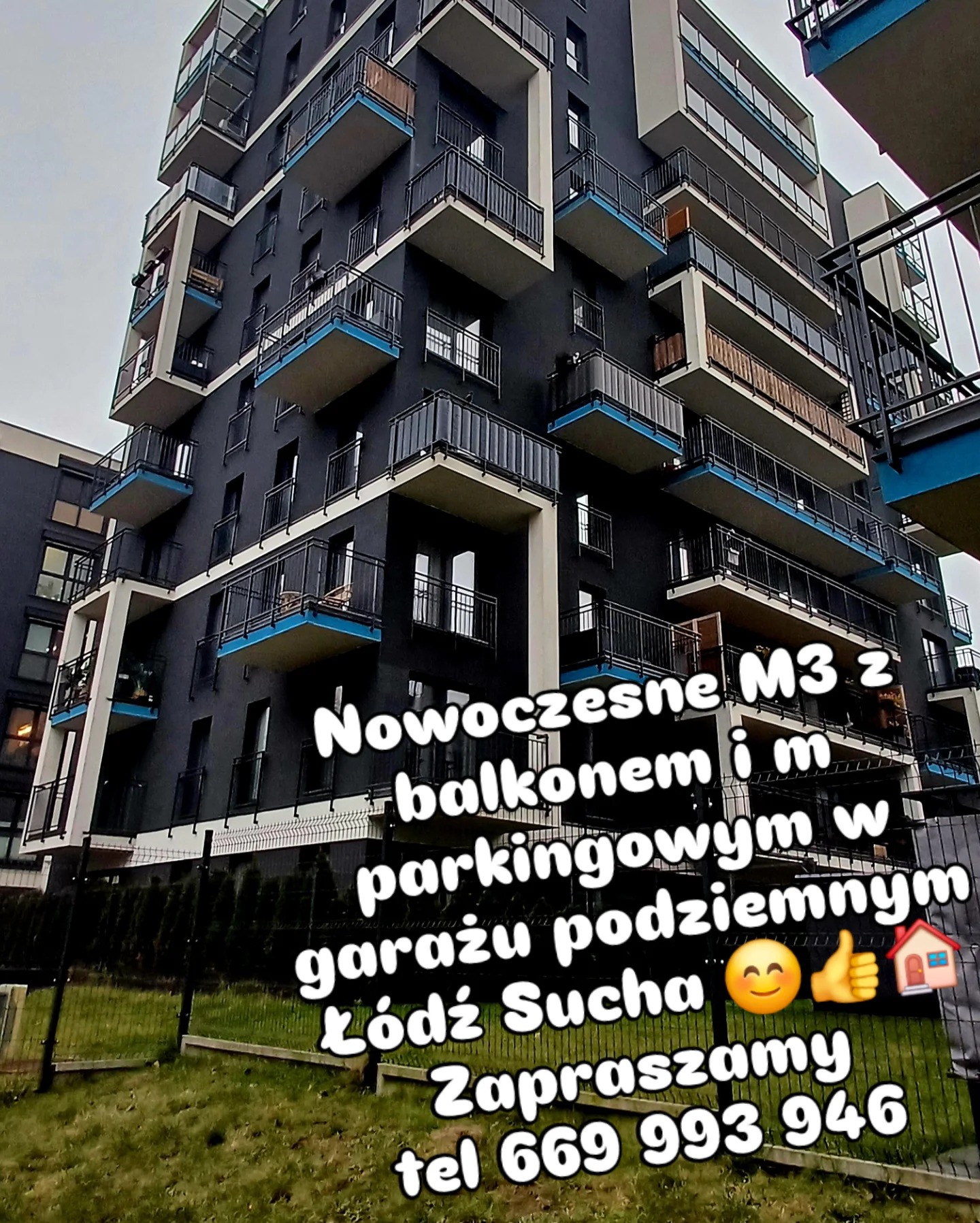 Nowoczesny apartamentowiec z balkonami w Łodzi. Budynek ma ciemną elewację z jasnymi akcentami. Widoczne ogrodzenie i zieleń. Na zdjęciu tekst z ofertą wynajmu.