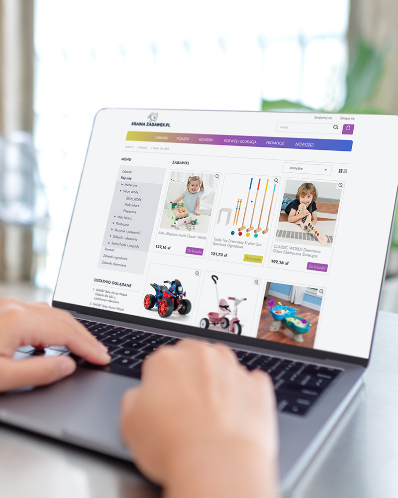 Osoba przegląda na laptopie sklep internetowy z zabawkami, widoczne kategorie zabawek i produkty w ofercie.
