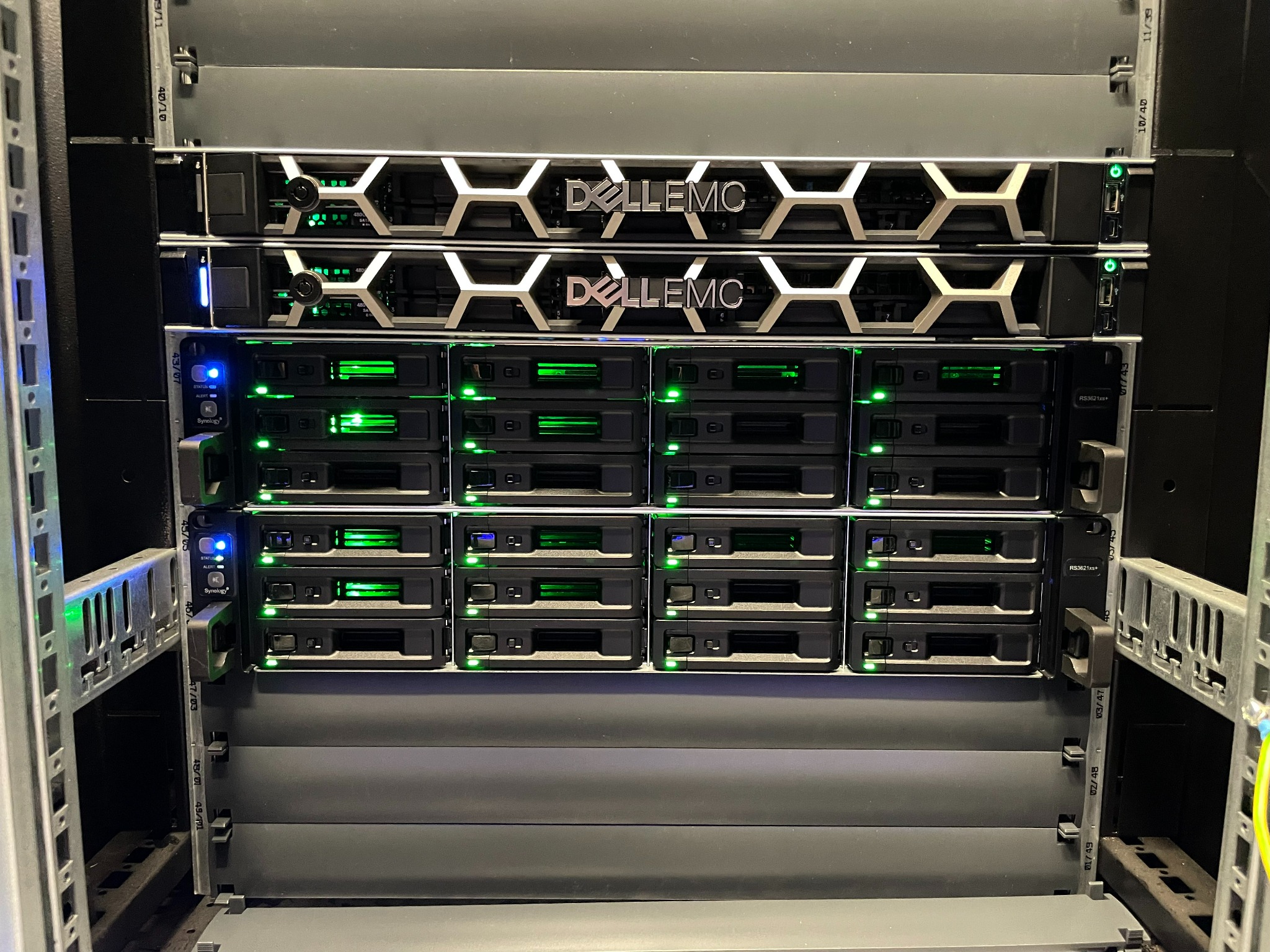 Serwerownia z urządzeniami Dell EMC i Synology, widoczne diody sygnalizacyjne i metalowa konstrukcja szafy rack.
