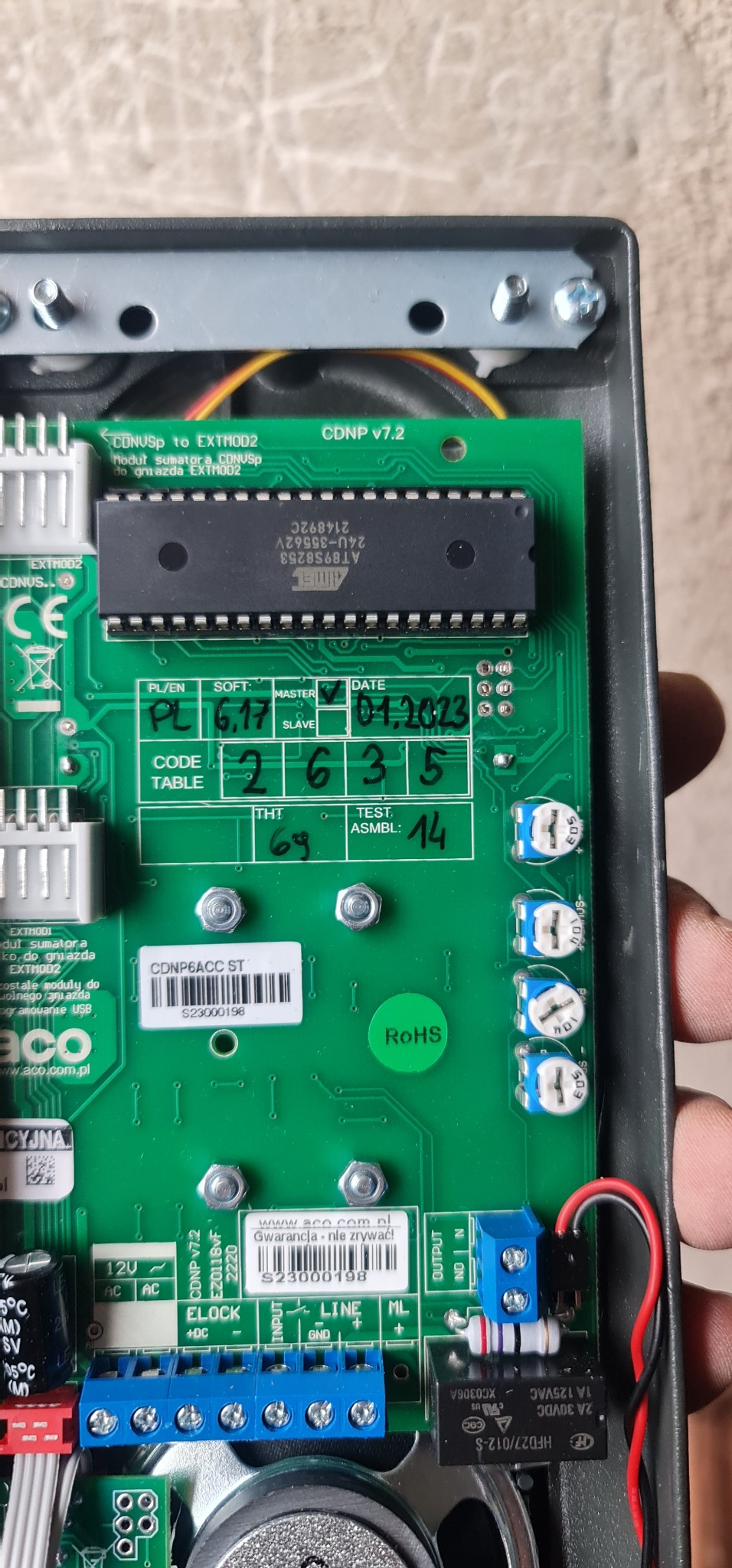 Płyta główna domofonu ACO CDNP v7.2 z widocznymi elementami elektronicznymi, chipem, konektorami, datą 01.2023 i naklejką z numerem seryjnym S23000198
