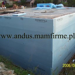 MATEO INTERNATIONAL Sp. z o.o. - Izolacja fundamentów styropianem ROOFMATE SL-A z widocznymi otworami okiennymi, przygotowana do dalszych prac budowlanych, z datą wykonania zdjęcia 2006/08/18.