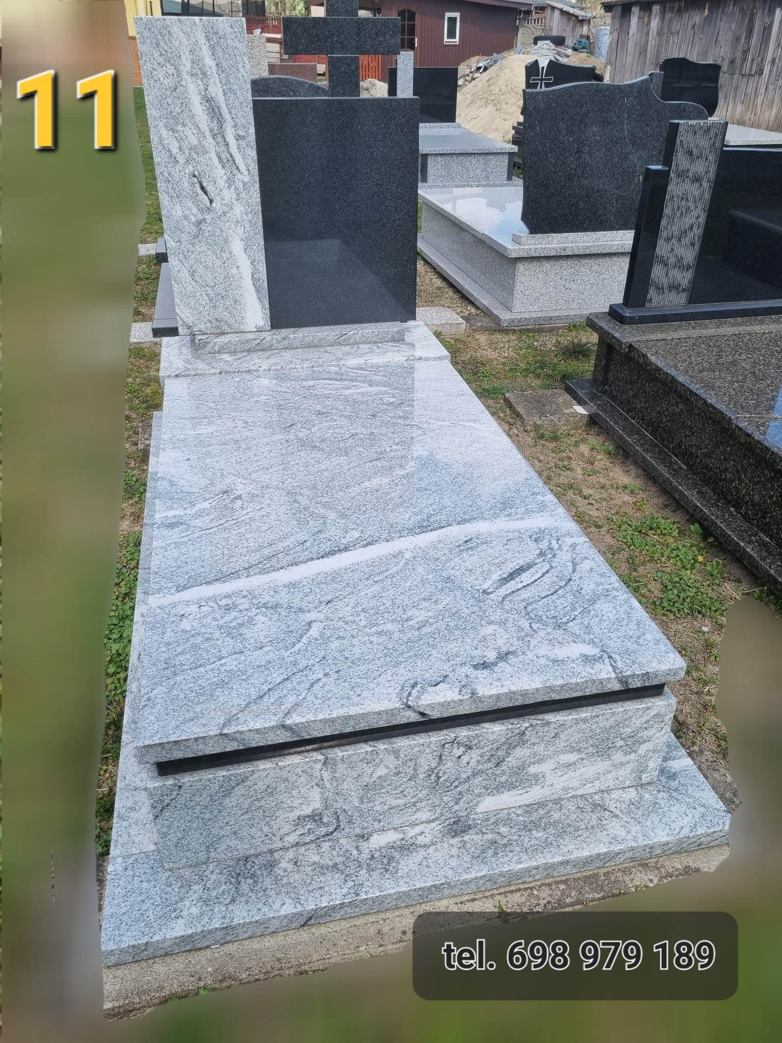 Jasnoszary, warstwowy nagrobek z granitu o wyraźnym wzorze, stojący na trawie, z numerem telefonu widocznym w dolnej części kadru.