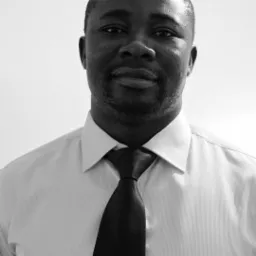 Portret biznesowy mężczyzny w koszuli i krawacie na jasnym tle, czarno-biały.