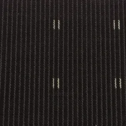 Ciemna wykładzina dywanowa z pionowymi prążkami i drobnymi, nieregularnymi, jasnymi akcentami na całej powierzchni.