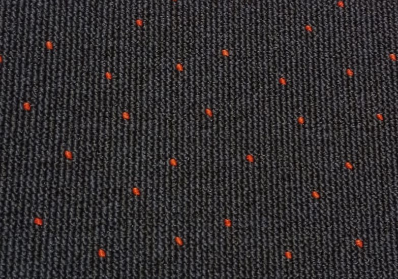 Ciemnoszara wykładzina dywanowa z regularnym wzorem małych, pomarańczowych kropek, widoczna z bliska, tekstura pętelkowa.