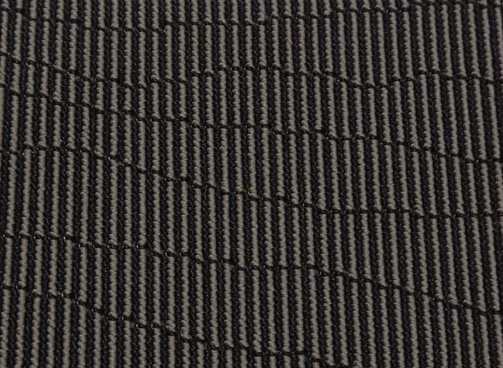 Ciemnoszara wykładzina dywanowa z prążkowaną teksturą, widok z bliska.
