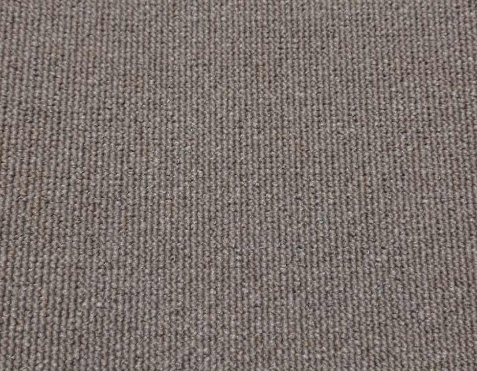 Zbliżenie na beżową wykładzinę dywanową o wyraźnej strukturze pętelkowej, z delikatnym cieniowaniem włókien.