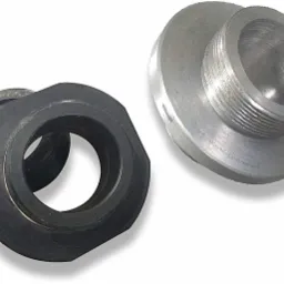 Dwa metalowe elementy: czarna nakrętka z oczkiem i srebrny element z gwintem, leżące na białym tle.