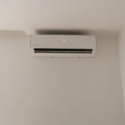 Biały klimatyzator ścienny marki Rotenso, ustawiony na 17 stopni, zamontowany w rogu jasnego pokoju.