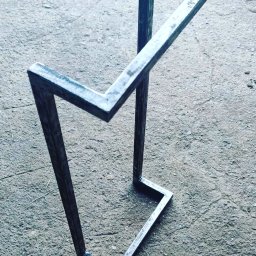 ParvisWelder Michał Gawarkiewicz - Surowy, geometryczny stojak metalowy z kwadratowych profili, spawany, widoczny na szarym betonowym podłożu.