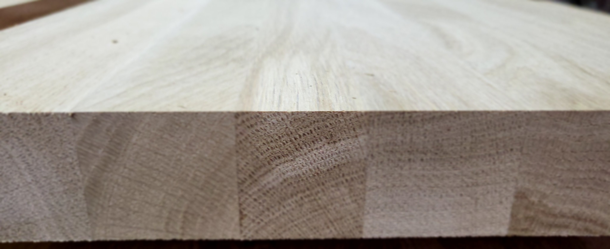 Przekrój przez klejonkę z jasnego drewna, widoczne słoje i struktura drewna.