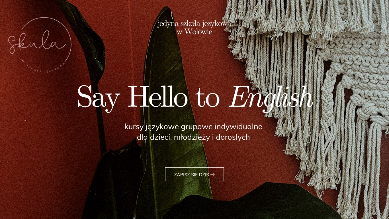 Logo szkoły językowej 'Skula' z hasłem 'Say Hello to English', oferującej kursy dla dzieci, młodzieży i dorosłych, na tle ciemnoczerwonej ściany z rośliną i makramą.