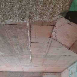 MIK-MONTAŻ Sp.z.o.o. - Montaż przewodów elektrycznych w nowo budowanym domu, widoczne kable przymocowane do sufitu oraz ściany z białych bloczków