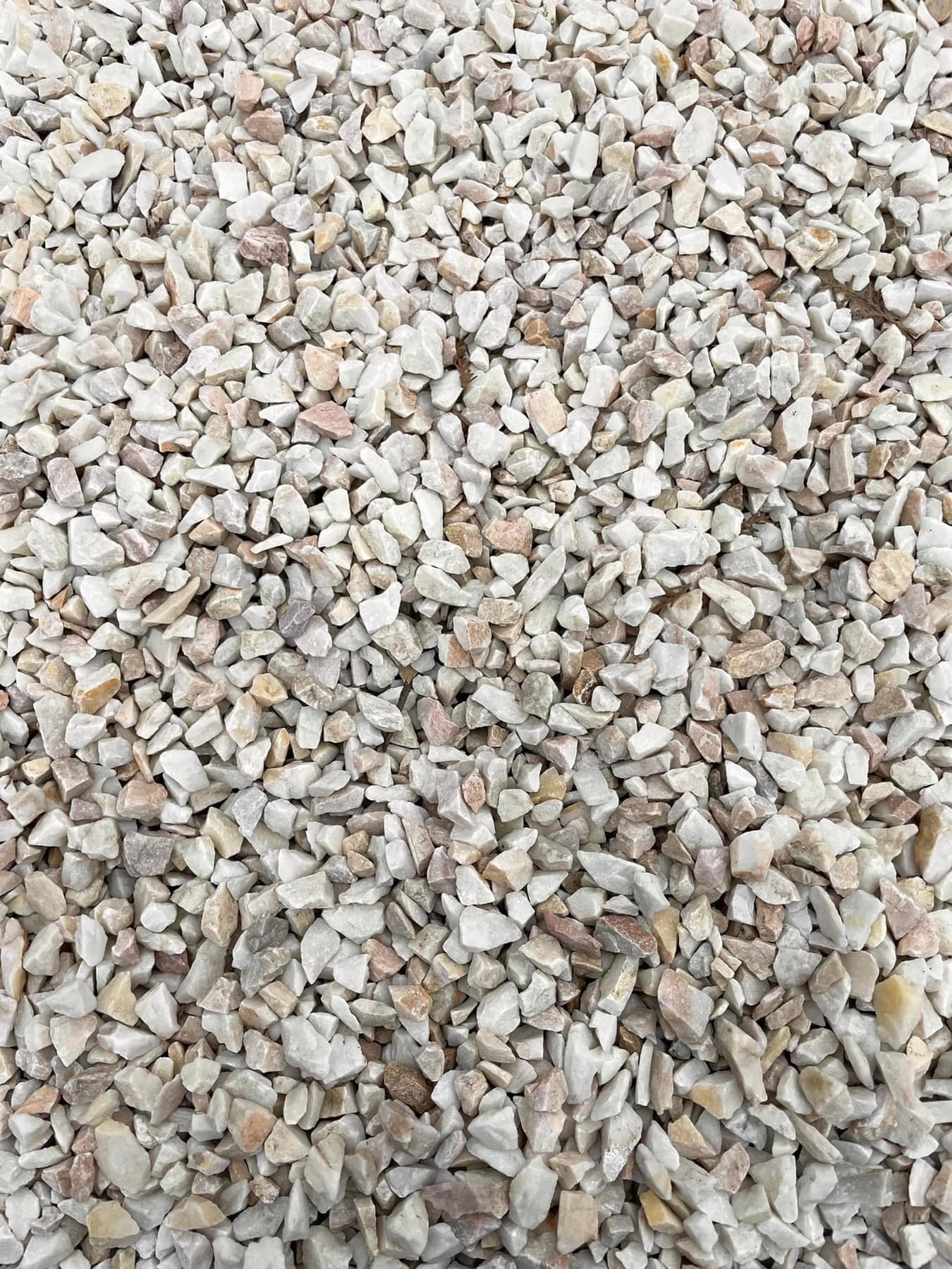 Drobny, biało-beżowy żwir marmurowy o nieregularnych kształtach, wypełniający całą powierzchnię kadru, z delikatnymi różowymi akcentami.