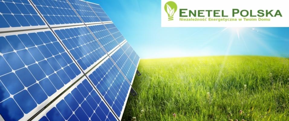 Panel słoneczny z widocznym logiem firmy Enetel Polska i hasłem Niezależność Energetyczna w Twoim Domu na tle błękitnego nieba i zielonego pola.