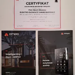 Certyfikat ukończenia szkolenia I stopnia Ampio, ulotka reklamowa inteligentnego domu Ampio oraz ulotka z panelami dotykowymi Ampio na jasnym tle.