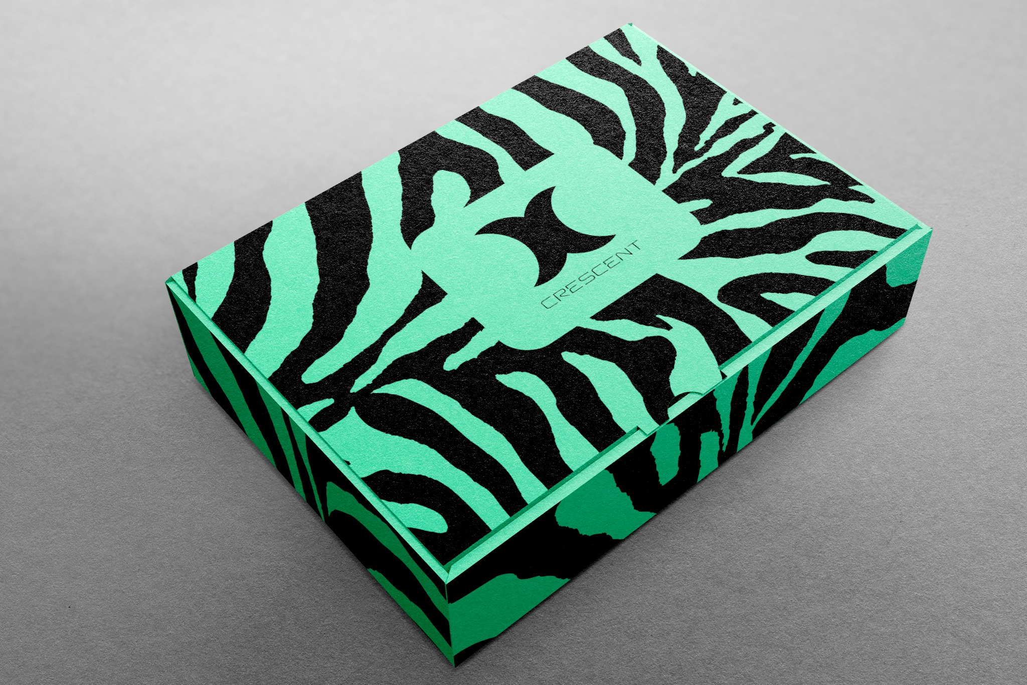 Pudełko z tektury w kolorze jasnej zieleni z czarnym wzorem zebry, na którym umieszczono logo firmy 'Crescent' w kolorze zielonym.