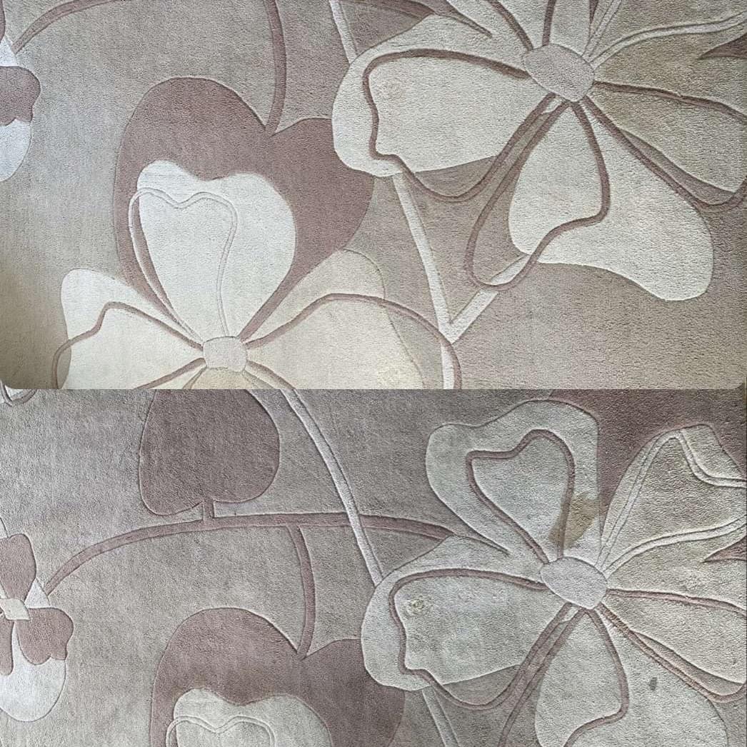 Fragment dywanu z motywem kwiatowym w odcieniach beżu i brązu, widoczna różnica w kolorze i czystości między górną a dolną częścią, sugerująca efekt czyszczenia.