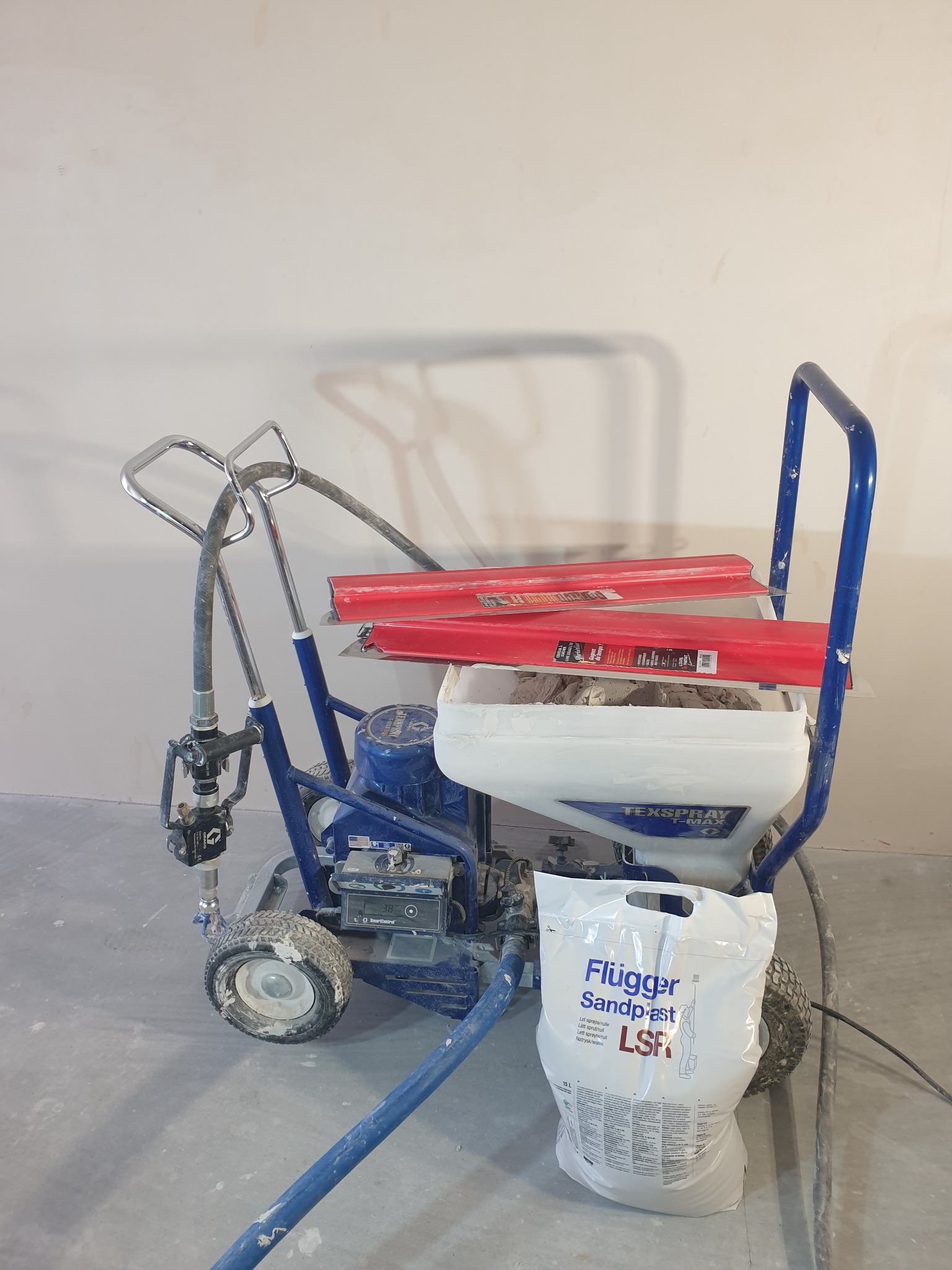 Agregat do natrysku szpachli Flugger Sandpast LSF z pacami do gładzi w Krakowie, gotowy do użycia na budowie.