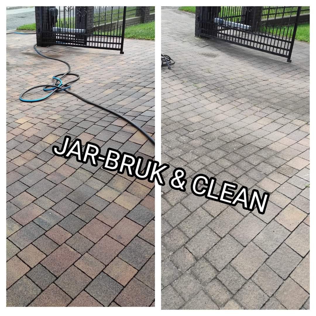 Porównanie stanu kostki brukowej przed i po czyszczeniu, widoczne różnice w kolorze i czystości, brama w tle, wąż ciśnieniowy na czystej części.