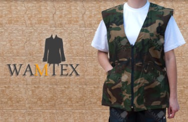 Osoba w kamizelce moro z dużymi kieszeniami na tle ściany z logo firmy WAMTEX.