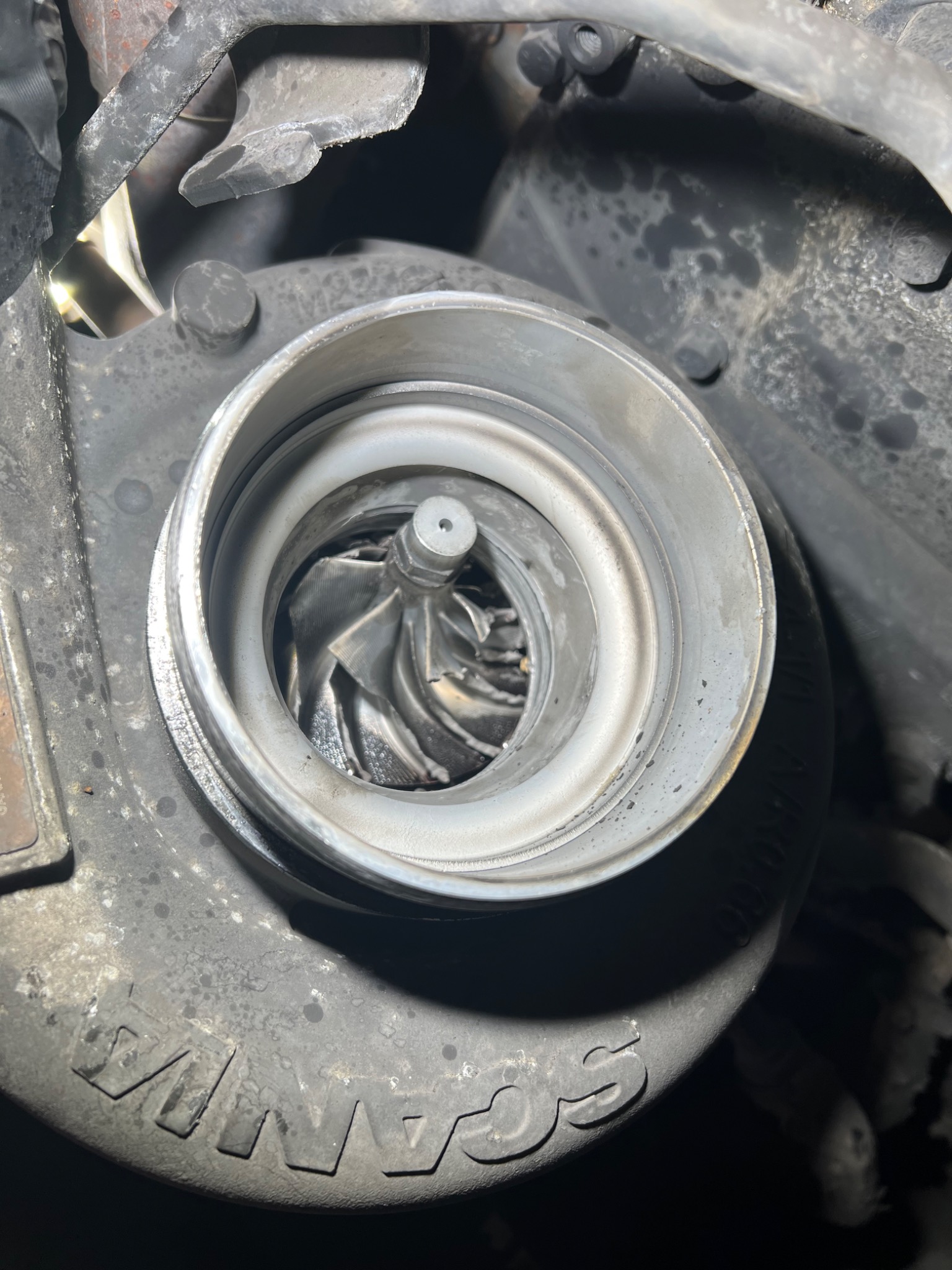 Otwarta turbosprężarka silnika, widoczne łopatki wirnika, zabrudzenia i ślady eksploatacji na obudowie.