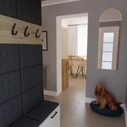 Wnętrze przedpokoju z wbudowaną szafą z tapicerowanymi panelami, drewnianym panelem z wieszakami i siedziskiem. W tle widoczne przejście do kuchni z wysokim blatem i hokerami oraz pies rasy spaniel...