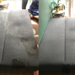 Dwuetapowe ujęcie szarego materaca: po lewej z widoczną plamą, po prawej po czyszczeniu, z niewielkim śladem w rogu. W tle widoczny pokój z roślinami i zasłonami.