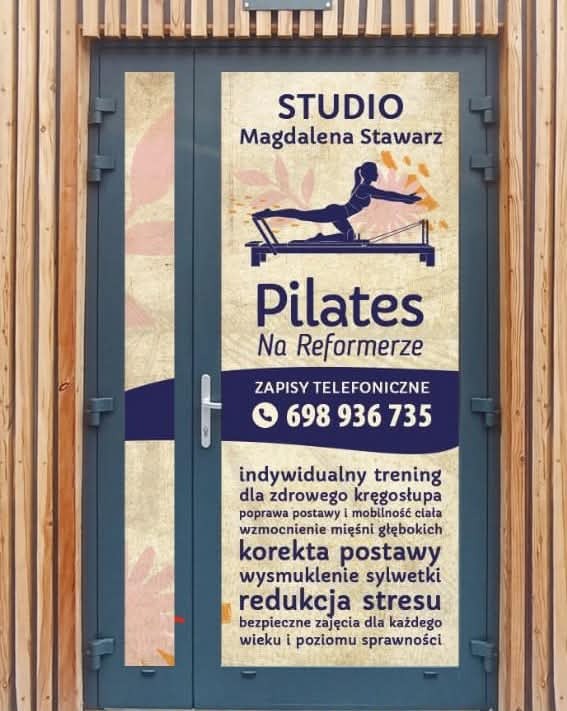 Wejście do studia Pilates Magdalena Stawarz, z grafiką kobiety ćwiczącej na reformerze, numerem telefonu i informacjami o treningach.