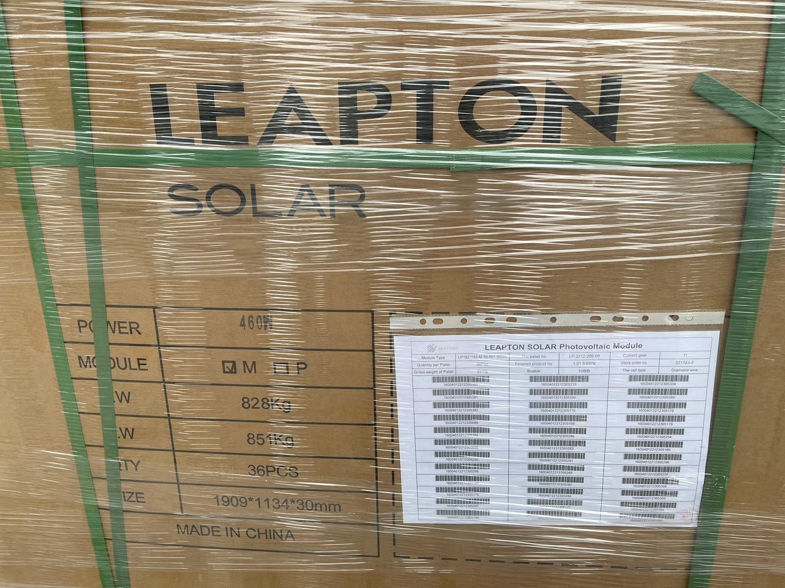 Paleta z modułami fotowoltaicznymi Leapton Solar, owinięta folią i zabezpieczona zielonymi taśmami. Widoczna etykieta z informacjami technicznymi modułów.