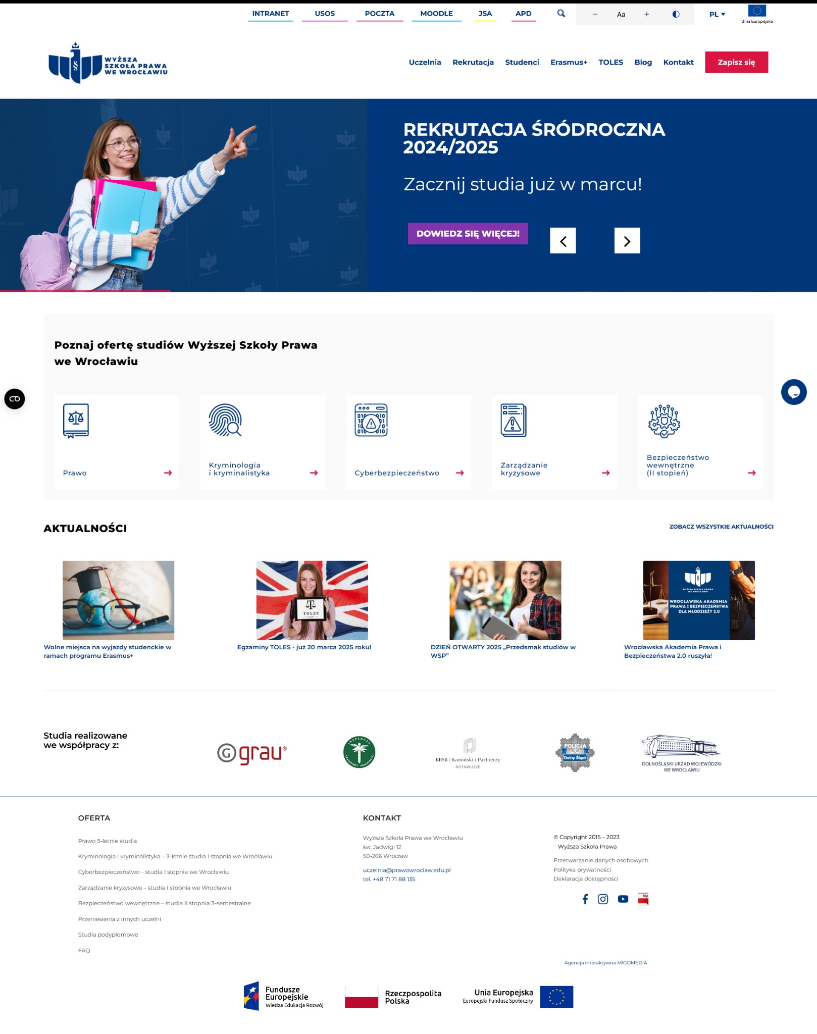 Uśmiechnięta studentka w okularach, z plecakiem i teczkami, prezentuje ofertę edukacyjną uczelni prawniczej we Wrocławiu, wskazując palcem w górę.