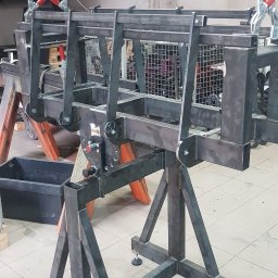 E&P PRO-METAL spółka jawna E.Luty P.Luty - Surowa, metalowa konstrukcja spawana na regulowanych nóżkach, z klamrami zaciskowymi, prawdopodobnie w warsztacie, na tle ściany z grzejnikiem.