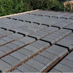 Strop Teriva ułożony z szarych pustaków stropowych, zbrojony stalowymi prętami, widok z góry na budowę domu jednorodzinnego.