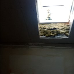 Krzysztof Slomski - Montaż okna dachowego w ścianie z płyt karton gips z widoczną izolacją z wełny mineralnej w przestrzeni między płytami.