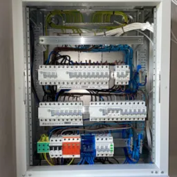 Rozdzielnica elektryczna z zainstalowanymi bezpiecznikami, zabezpieczeniami przepięciowymi i okablowaniem, widok z bliska, firma EATON i ELEKTRO-PLAST.