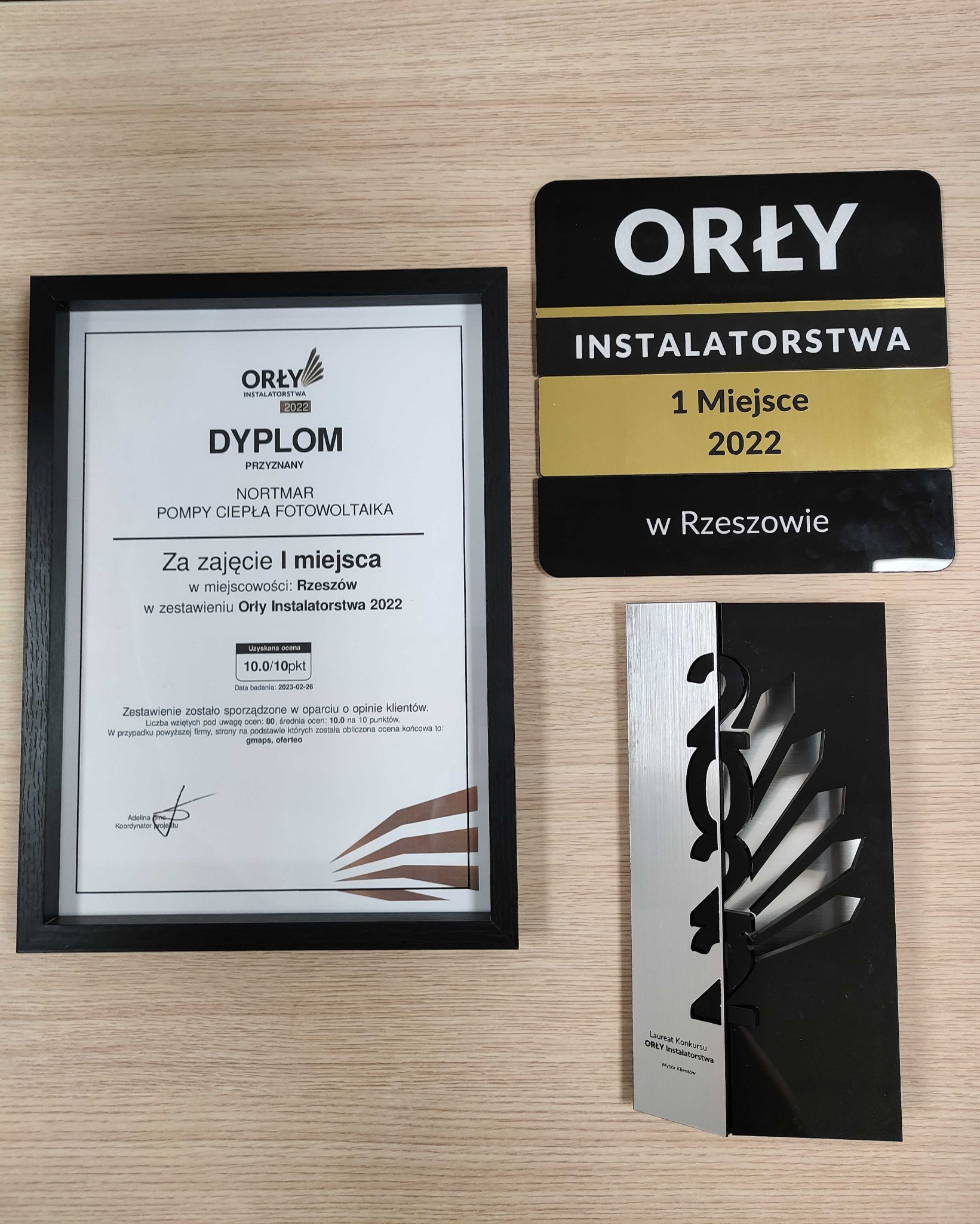 Dyplom i statuetki 'Orły Instalatorstwa 2022' dla firmy Nortmar za 1. miejsce w Rzeszowie w kategorii pompy ciepła i fotowoltaika, z oceną 10/10 punktów na podstawie opinii klientów z Google Maps...