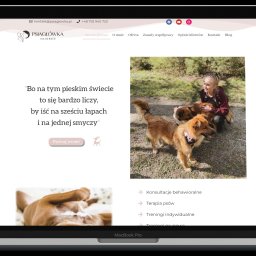 NETIGER Kamil Pyszkiewicz - Ekran laptopa MacBook Pro wyświetlający stronę internetową Psiagłówka Igi Berner z wizerunkiem kobiety z psami na tle zieleni.