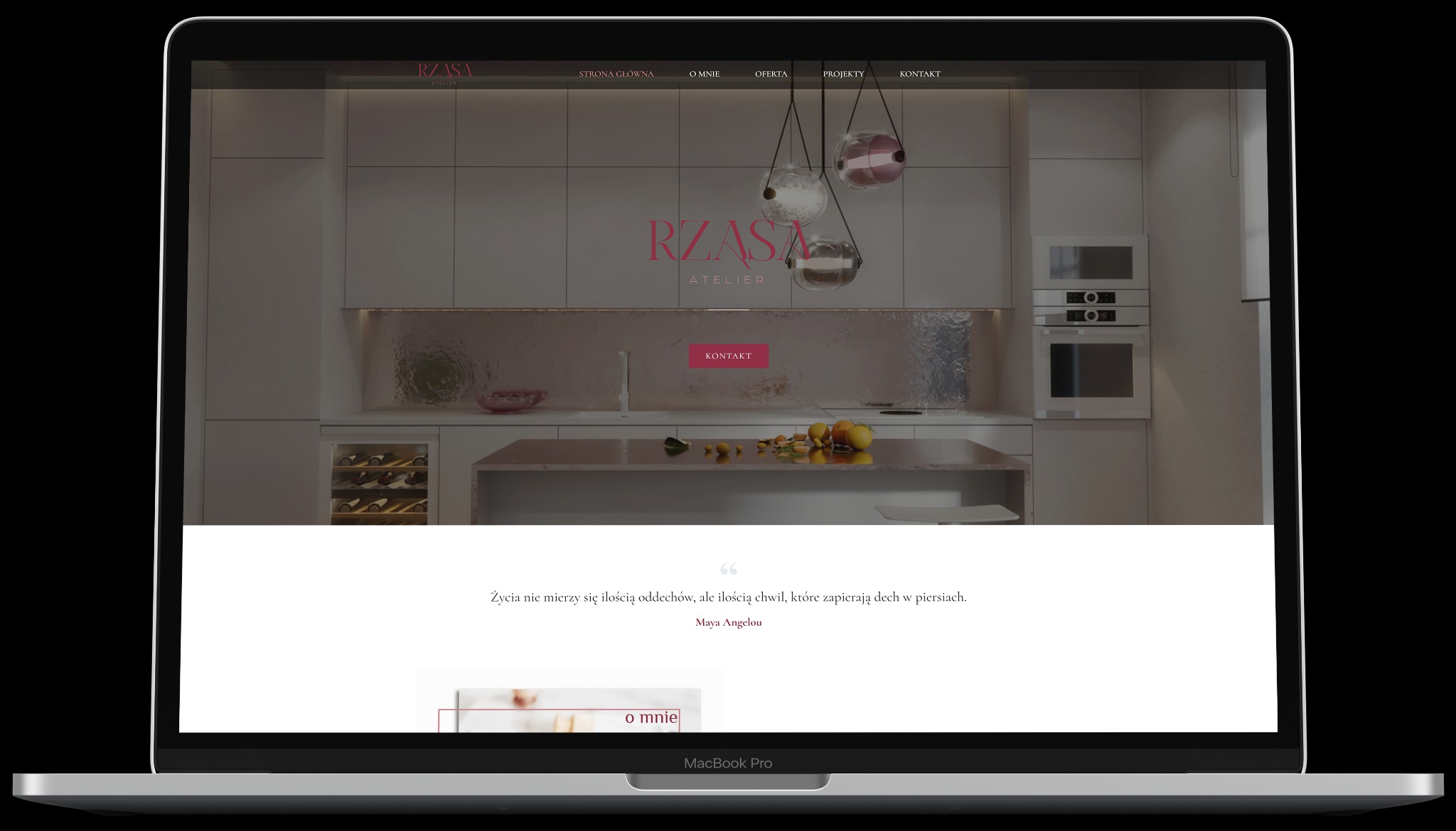 Ekran laptopa MacBook Pro prezentuje stronę internetową z minimalistycznym designem, ukazującą wizualizację nowoczesnej kuchni z elementami dekoracyjnymi i owocami na blacie, a także menu...