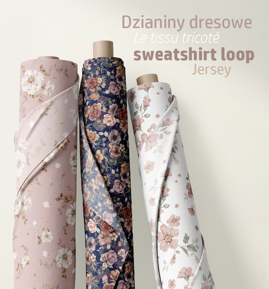 Trzy rolki dzianiny dresowej z kwiatowymi wzorami: różowa z białymi kwiatami, granatowa z różowymi i brązowymi różami oraz biała z delikatnymi różowymi kwiatami, ustawione na jasnym tle.