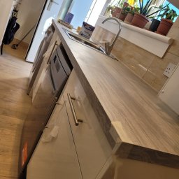 jakub surowiec - Nowa, jasna kuchnia z marmurowym blatem, chromowaną baterią i roślinami w doniczkach na parapecie, widoczna puszka farby Dulux White na blacie.