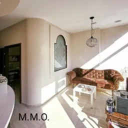 Jasne wnętrze biura z zaokrąglonymi ścianami, dekoracyjną wnęką okienną z geometrycznym wzorem, brązową sofą z guzikami, nowoczesną lampą wiszącą i marmurową ladą recepcyjną z ozdobnym słoikiem...