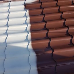 MW Team - Częściowo pomalowany dach z brązowej blachodachówki na biało, widoczny kontrast między starą a nową powłoką, zbliżenie na proces malowania dachu.