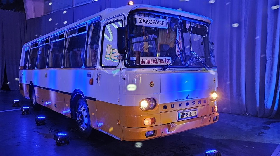 Autosan H9-21 z tablicą 'Zakopane' i napisem 'do DWORCA PKS 150', oświetlony niebieskim światłem od dołu, stoi na scenie.