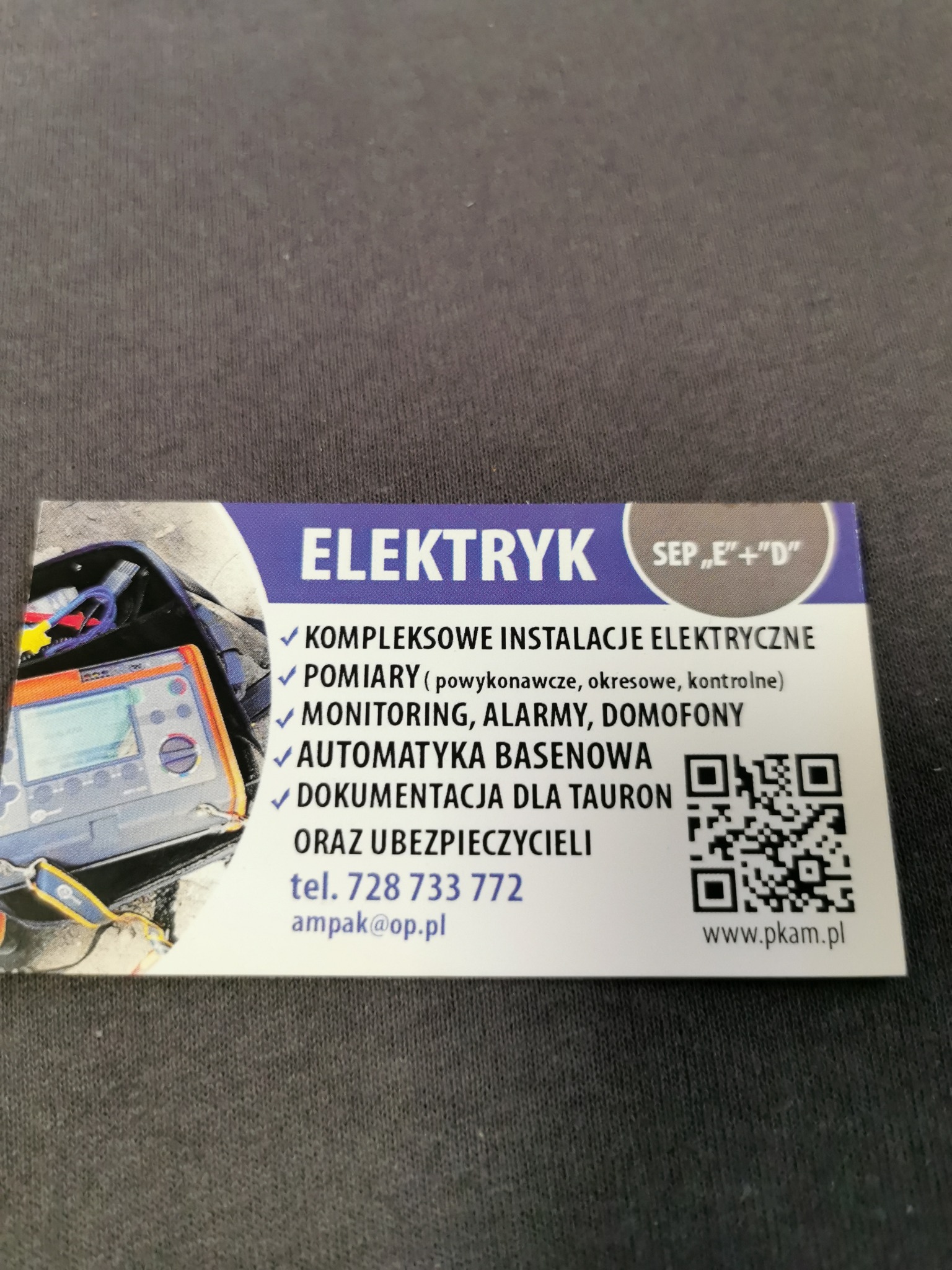 Wizytówka elektryka z listą usług: kompleksowe instalacje elektryczne, pomiary, monitoring, alarmy, domofony, automatyka basenowa, dokumentacja dla Tauron i ubezpieczycieli. Zawiera numer telefonu,...