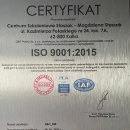 Metalowa tablica certyfikatu ISO 9001:2015 dla Centrum Szkoleniowego Staszak w Kaliszu, potwierdzającego świadczenie usług szkoleniowych, w tym kursów prawa jazdy kategorii B, doskonalenia techniki...